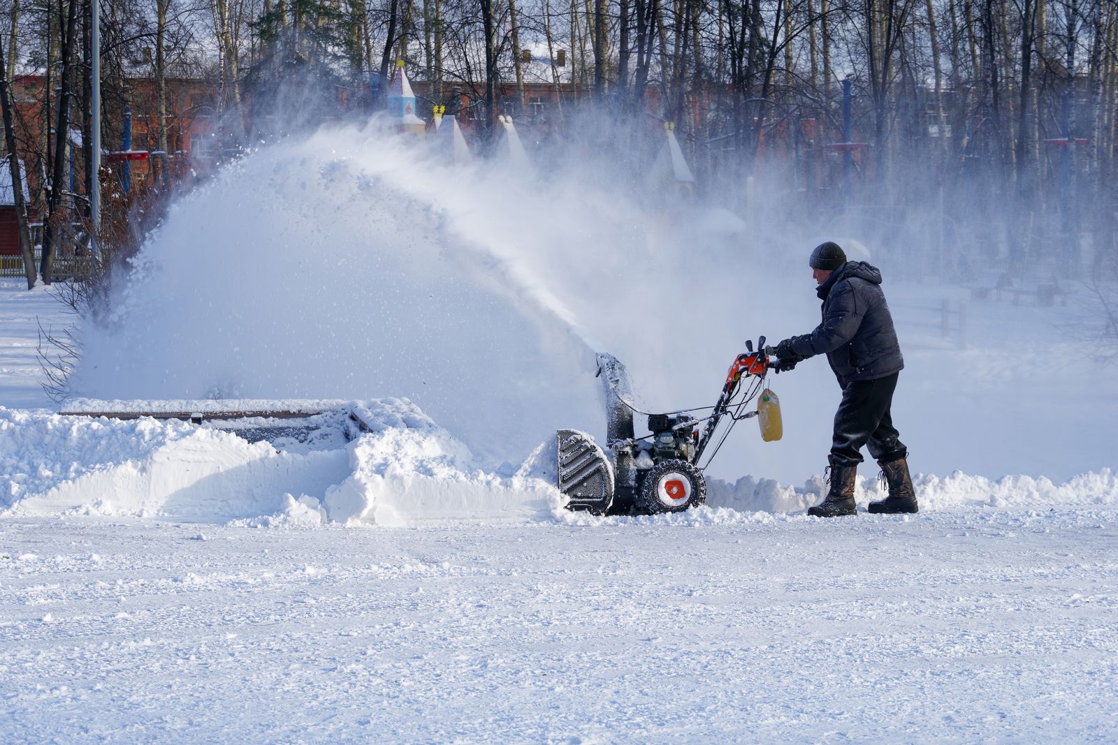 Two-stage snow blower throwing a large plume of snow